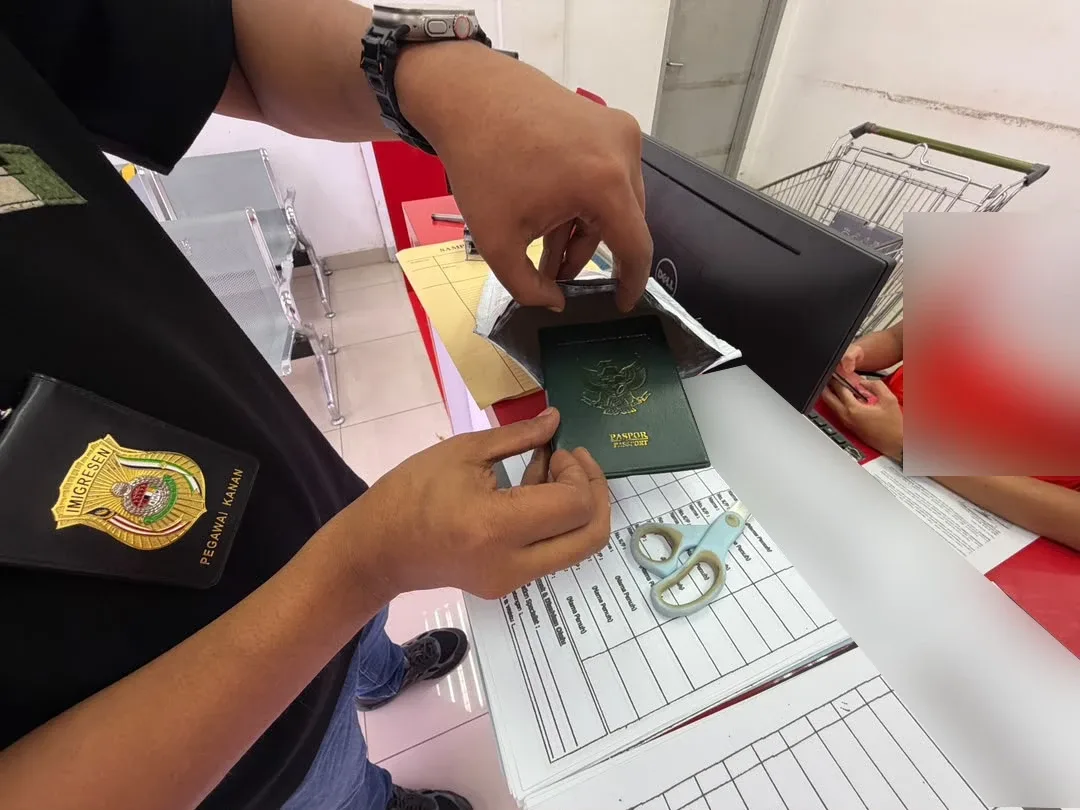 Pegawai memeriksa pasport dalam operasi di Shah Alam.