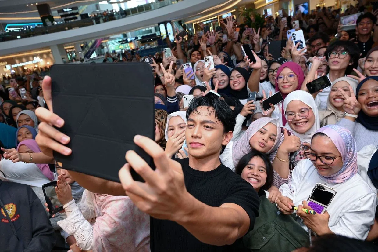 Zarif Ghazzi merakam gambar bersama peminat yang hadir ke sesi ramah mesra.